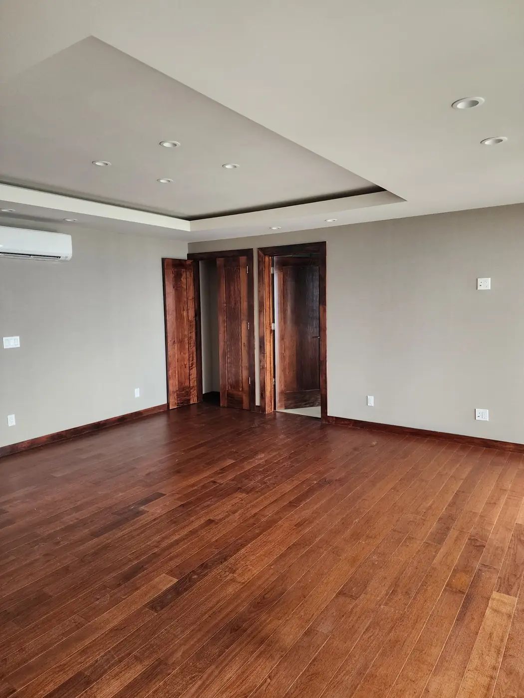 Black Point: bedroom suite with stained hardwood floor and matching stained pocket doors, color-matched throughout
