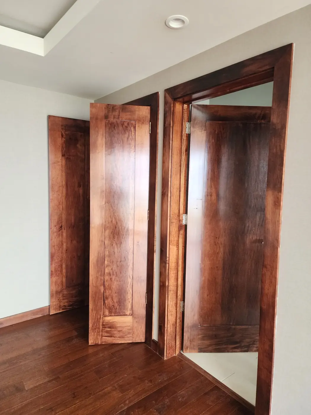 Black Point: hand-stained interior doors color-matched to the new hardwood floor, walnut blended into pine to read as koa