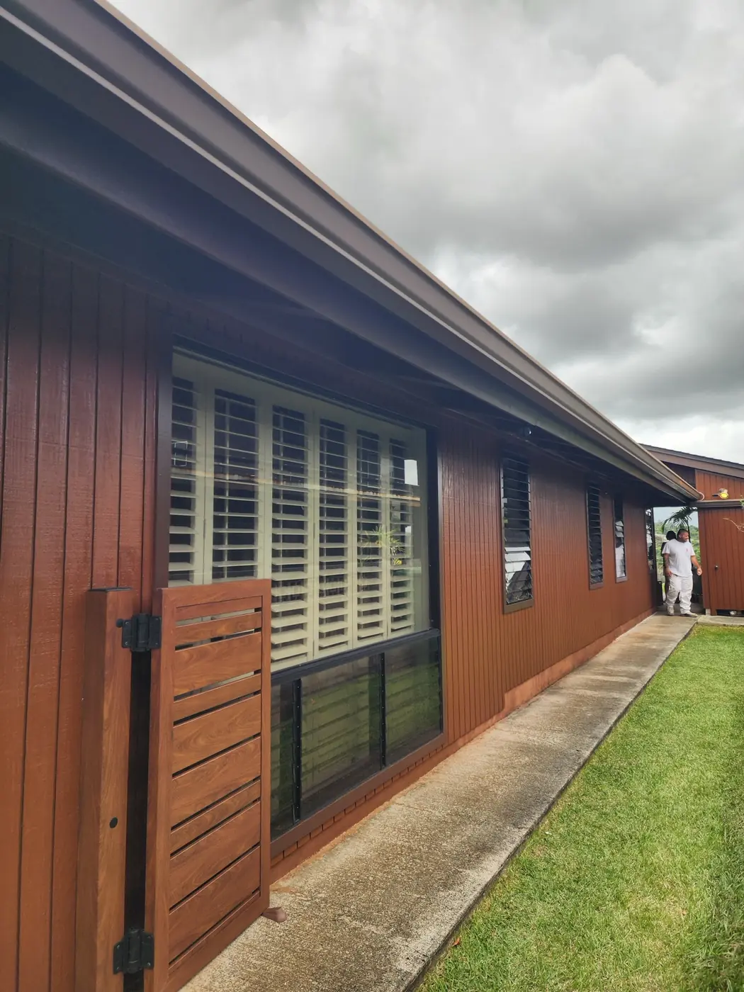 Exterior wood stain finished in deep walnut on a Hawaii residence, siding and trim color-matched