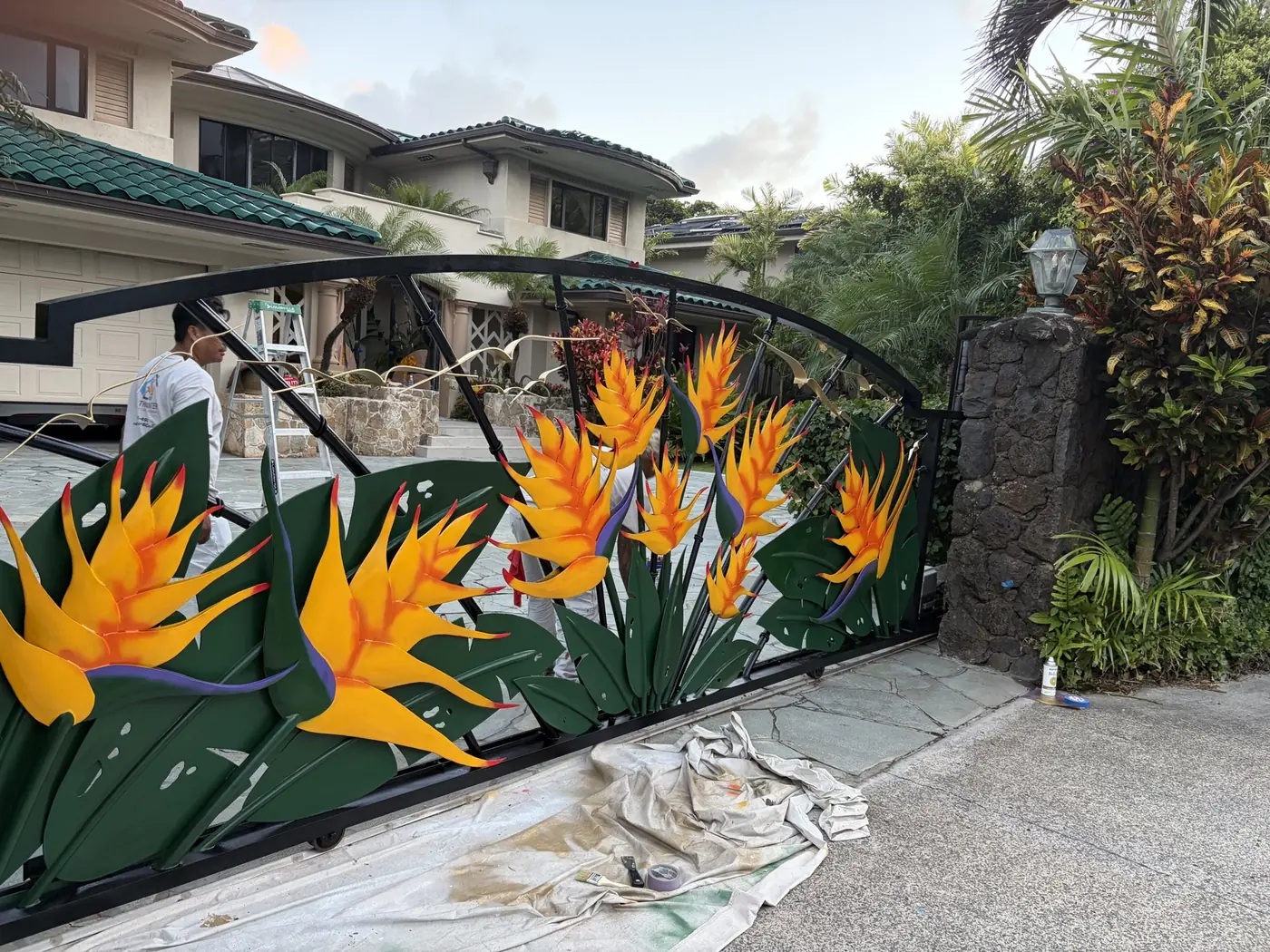 The same gate hand-painted with vivid orange birds of paradise rising through deep green foliage, finished on site by Rob the Painter