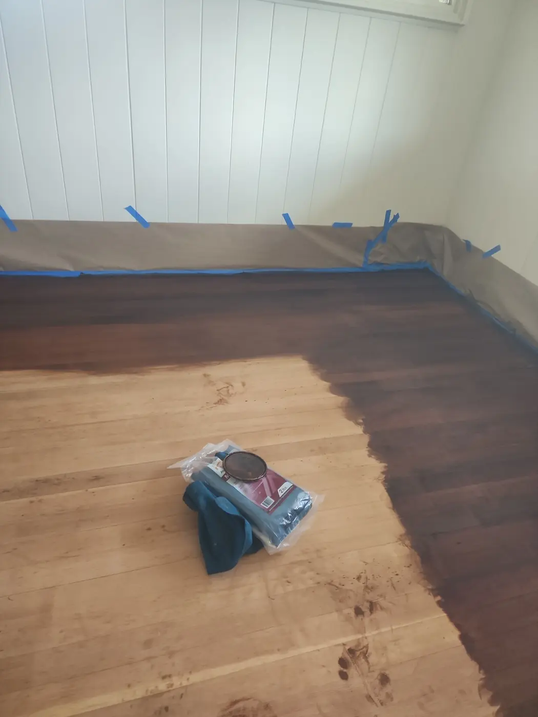 Hardwood floor refinish: second angle of the finished planks with the masked baseboard line visible