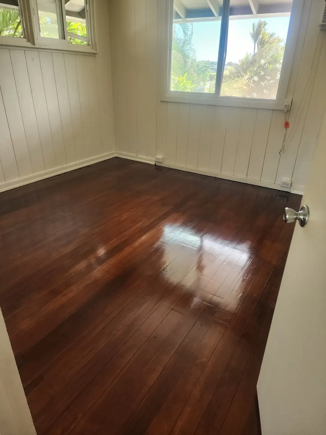 Hardwood floor refinish: corner detail, baseboard clean, edges crisp
