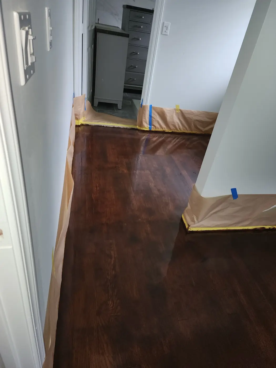 Hardwood floor finish: wider view of the restored room, clean lines along the baseboard
