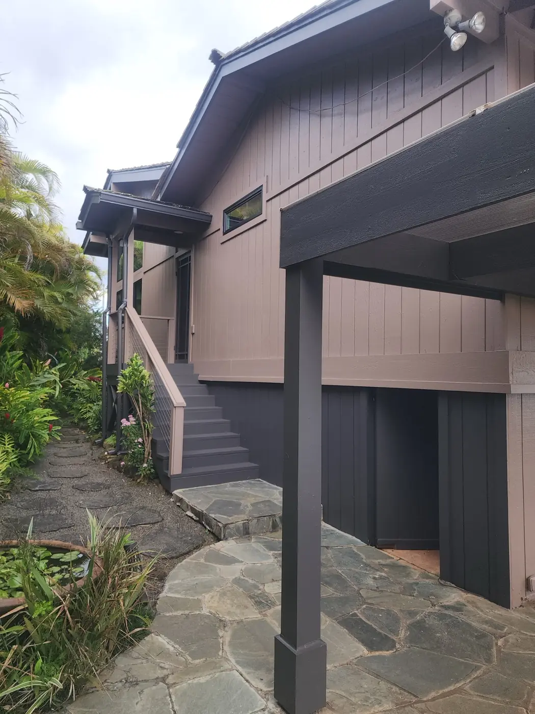 Hawaii Kai exterior: roofline and soffit details finished, clouds breaking behind