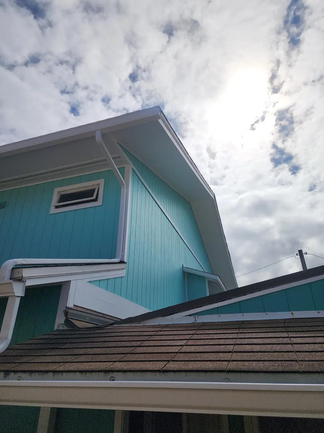 Kailua exterior: full elevation showing the warm finished siding against clouds