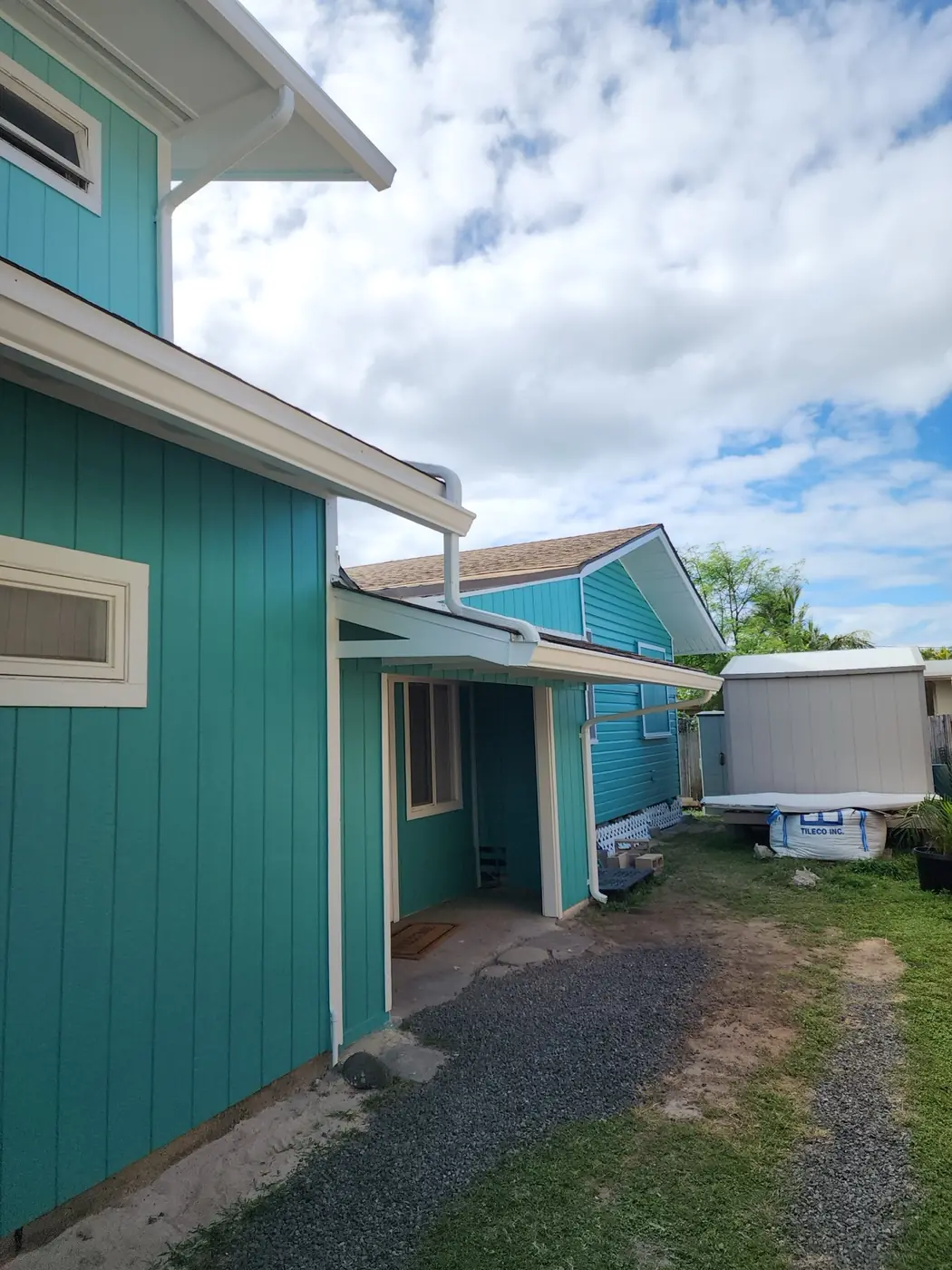 Kailua exterior: angled view of the finished home with lawn and palms