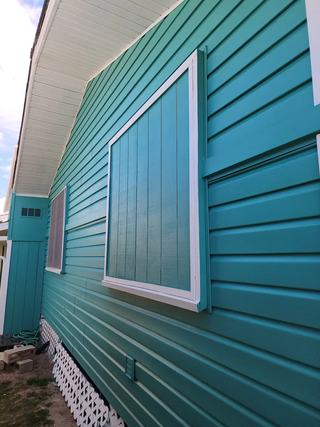 Kailua exterior: side elevation with finished siding and trim, blue sky overhead