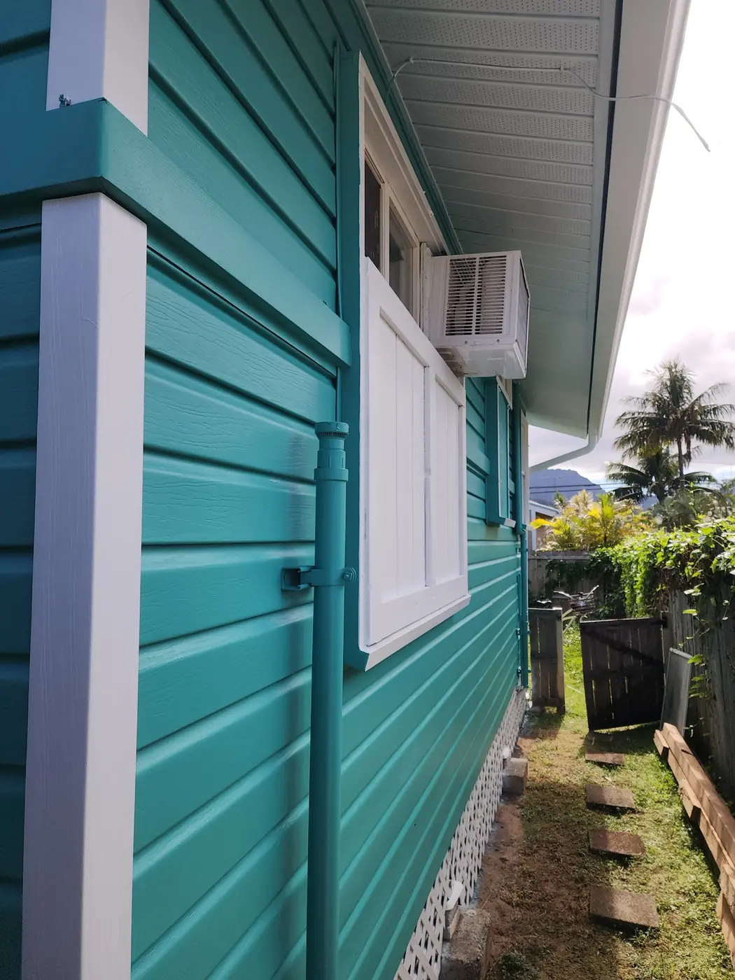 Kailua two-story residence finished in deep warm brown siding with crisp white windows