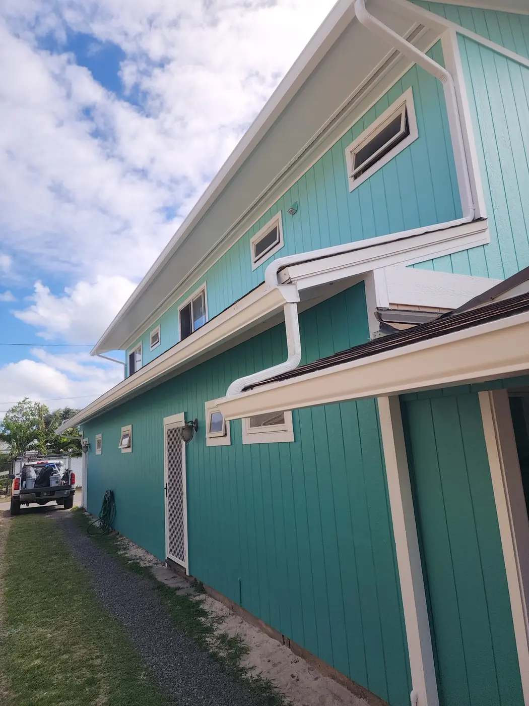 Kailua exterior: wraparound deck and finished siding under bright sky